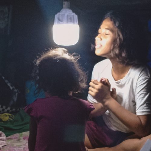 Shining with gratitude: Ecko's nieces happily receiving the donated solar lamps